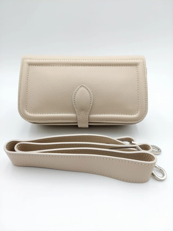 Skórzana kopertówka w kolorze ecru  z odpinanym, regulowanym paskiem na ramię, widok od przodu.