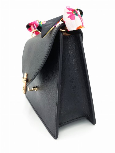 Czarna torebka skórzana o strukturze saffiano widziana z boku, sztywny fason z metalowym zapięciem i kolorową apaszką przy rączce.