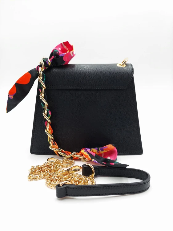 Tył czarnej torebki skórzanej z widocznym odpinanym długim paskiem oraz złotym łańcuszkiem z różową apaszką w kwiaty